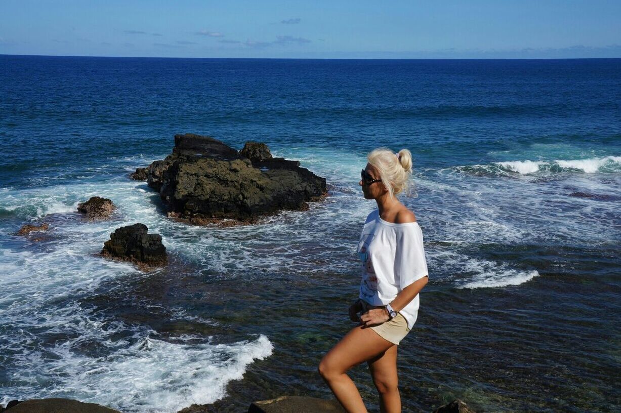 sea, water, horizon over water, leisure activity, lifestyles, full length, beauty in nature, vacations, scenics, rock - object, wave, nature, rear view, beach, tranquil scene, rock formation, standing, tranquility