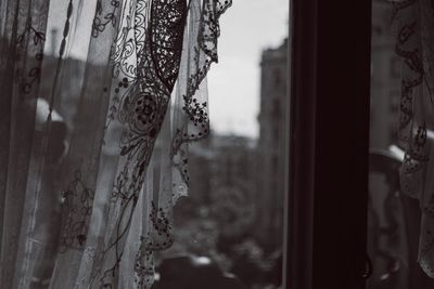 Close-up of curtain on glass window at home