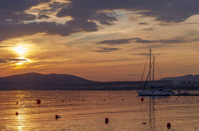 Sailboats in sea against sky during sunset