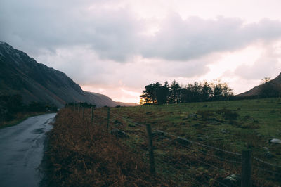 Scenic view of field against cloudy sky