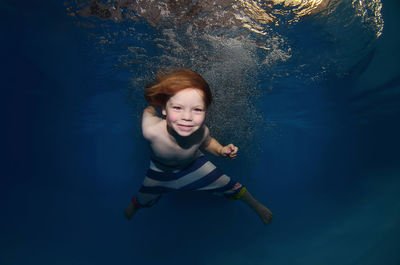Portrait of smiling boy swimming in sea