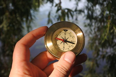 Cropped hand holding navigational compass