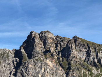 Low angle view of rocky mountains against sky