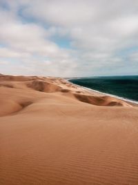 Scenic view of beach against dramatic sky