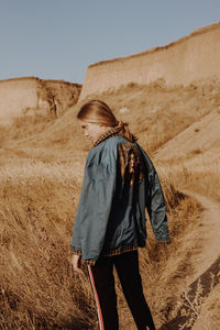 Rear view of woman walking on field