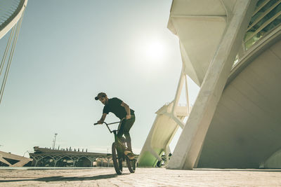 Man performing stunt on bicycle in city 