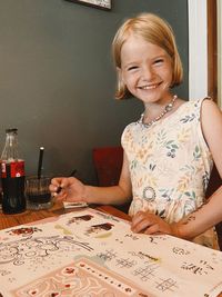 Portrait of young woman sitting on table