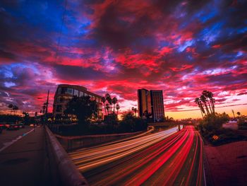 Light trails on road against sky during sunset