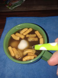 Close-up of hand holding bowl of food