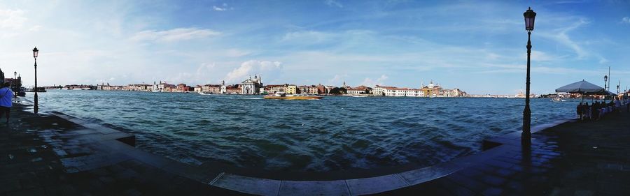 Panoramic view of buildings by sea against sky