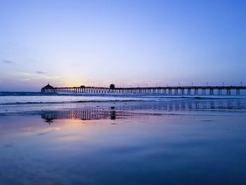 Pier over sea against sky during sunset