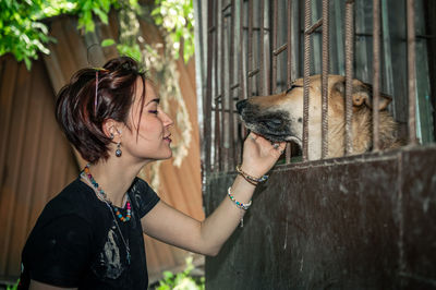 Dog at the shelter.  lonely dogs in cage with cheerful woman volunteer