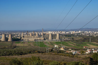 Buildings in city against clear blue sky