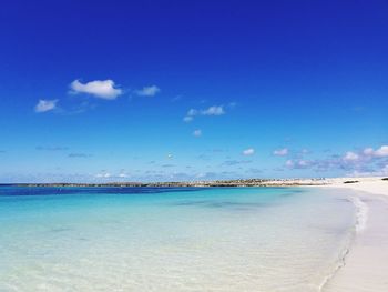 Scenic view of beach against blue sky