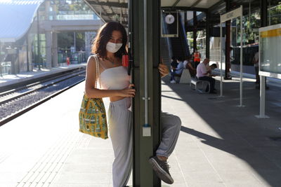 Woman standing on railroad station platform