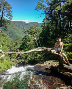 Man sitting on rock by lake