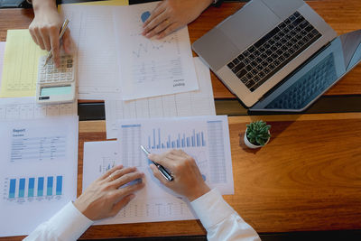 Midsection of business people working on table