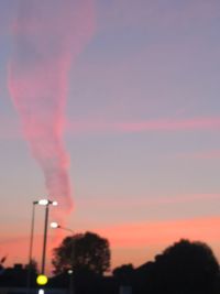 Smoke emitting from factory against sky during sunset