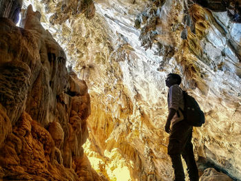 Rear view of man standing on rock