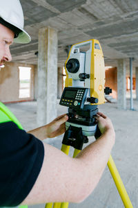 Surveyor engineer working at construction site with measuring equipment (total station)