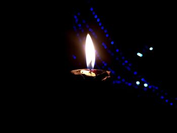 Close-up of lit candle in dark room