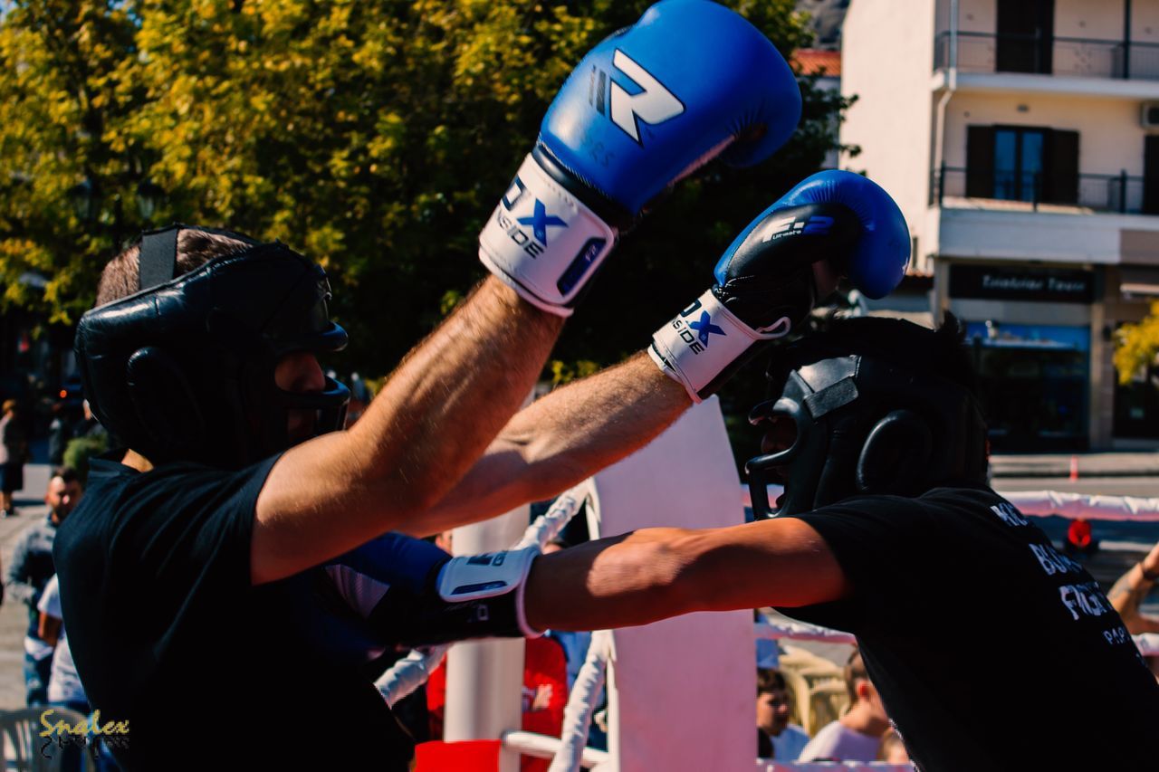 MIDSECTION OF MAN WITH ARMS RAISED IN BACKGROUND