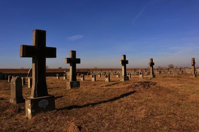 Cross on cemetery against sky