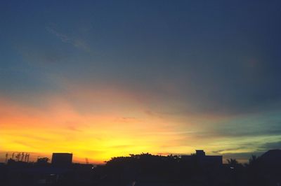 Silhouette cityscape against sky during sunset