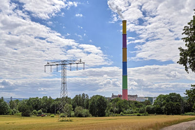 Electricity pylon on field against sky