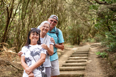 Portrait of smiling senior couple standing in forest