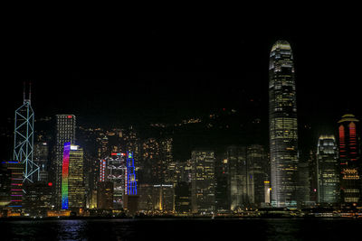 Victoria harbor against illuminated buildings at night