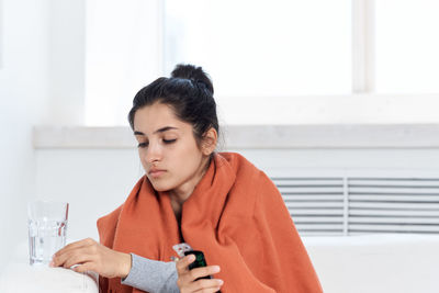 Young sick woman sitting at home