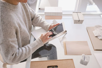 High angle view of female interior designer using digital tablet at desk in store