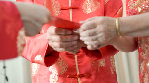 Midsection of people holding greeting card 