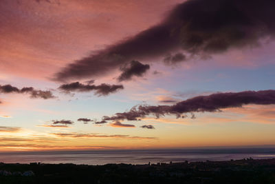 Scenic view of dramatic sky over silhouette landscape