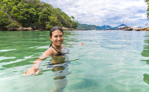 Woman swimming at the green lagoon on the tropical island ilha grande