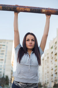 Young woman exercising against sky