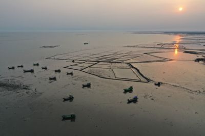 High angle view of sea shore against sky during sunset