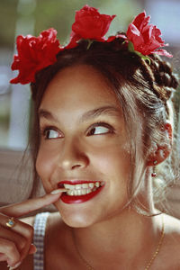 Close-up of smiling young woman biting nail while looking away