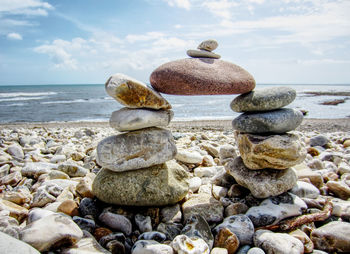 Close-up of pebbles on beach against sky