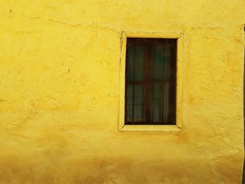 Close-up of window on yellow wall of building