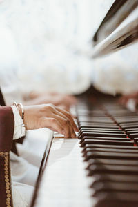 Cropped hand of person playing piano