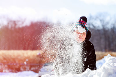 Portrait of boy playing with snow