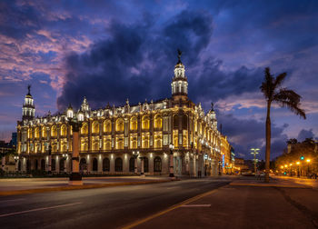 Illuminated national theater of cuba by road against sky at dusk
