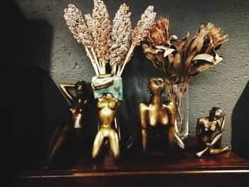 Close-up of statue on table against wall