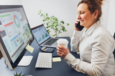 Woman entrepreneur having business conversation on mobile phone. businesswoman working with charts