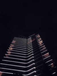 Low angle view of illuminated buildings against sky at night