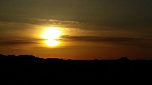 Scenic view of silhouette mountain against dramatic sky during sunset