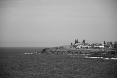 Scenic view of sea and buildings against clear sky