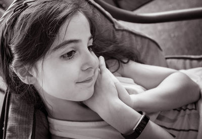 Close-up of smiling girl sitting on chair at home